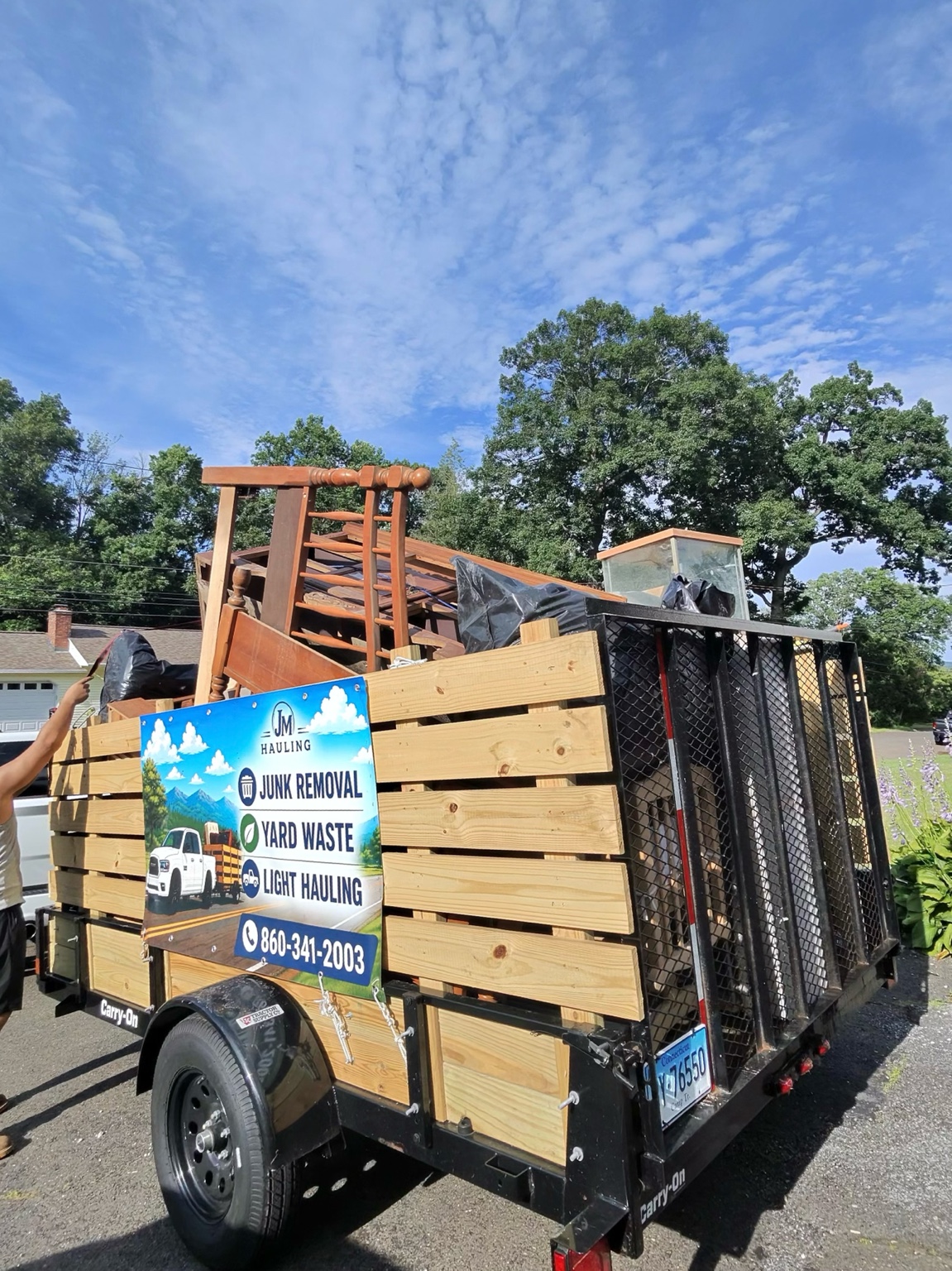 JM Hauling trailer fully loaded after a junk removal job